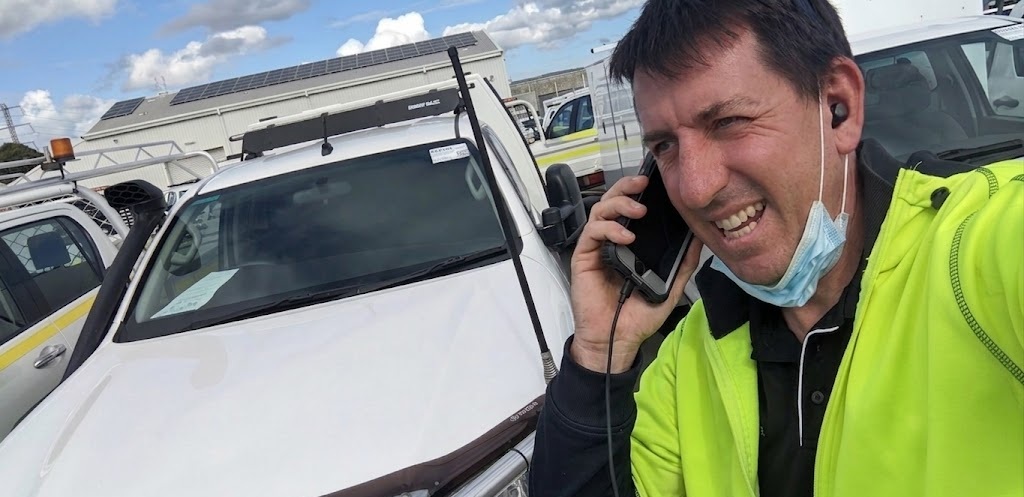 Site supervisor on a mobile phone trying to coordinate field workers at a construction site